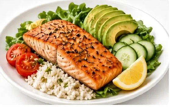 Salmon bowl with avocado, greens, rice, tomatoes and lemon